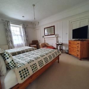 埃尔金Moraybank Bed & Breakfast的一间卧室配有两张床和一台平面电视
