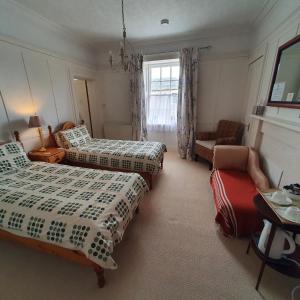 埃尔金Moraybank Bed & Breakfast的一间卧室配有两张床、一张沙发和一把椅子