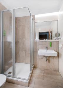 玛利亚采尔JUFA Hotel Mariazell的带淋浴和盥洗盆的浴室