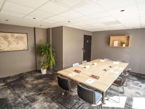 图尔Ibis Tours Centre Giraudeau的一间会议室,配有一张大木桌子和椅子