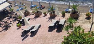 阿马林索斯阿耳特弥斯酒店的海滩上的一组椅子和遮阳伞