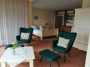 Bösdorf法尔豪斯尼德尔科莱维兹酒店的客房设有床、两张绿色椅子和一张桌子