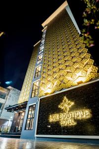 暖武里府Lux Boutique Hotel的一座大型建筑,晚上有豪华的精品酒店