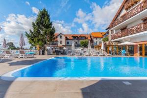 库瑞尼卡慕斯卡卡赫尔贝格酒店的一个带椅子和遮阳伞的度假村游泳池