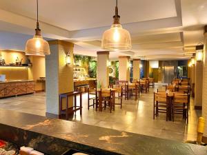 纳塔尔纳塔尔杜纳斯酒店的餐厅设有木桌和椅子及灯