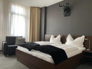 杜塞尔多夫林德霍夫酒店的一间卧室配有一张大床和一把椅子