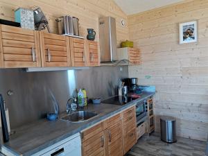 DigosvilleAu courtil des chênes marins, meublé 3 étoiles的一个带木制橱柜和水槽的厨房