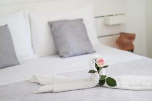 巴里奥罗拉之家住宿加早餐酒店的一张白色的床,上面有玫瑰花