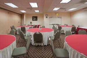 特雷西特雷西快捷假日酒店及套房的一间会议室,配有红色和白色的桌椅