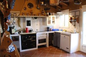 Los CortosCasa Rural Rincon de la Vega的厨房配有白色家电和棕色瓷砖地板。