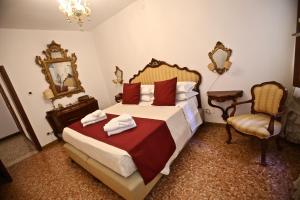 威尼斯Ca Donzela的一间卧室配有一张床、一把椅子和镜子