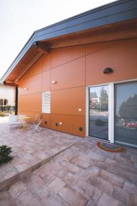 龙基德伊莱焦纳里B&B OASI的橙色的建筑,设有庭院和桌子