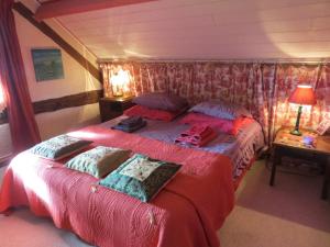 Notre-Dame-de-Courson香特德非旅馆的一间卧室配有一张带红色床单和枕头的床。