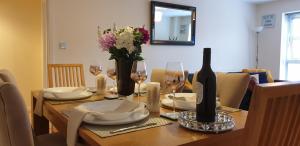 伯明翰Elite luxury apartment的餐桌,配有一瓶葡萄酒和鲜花