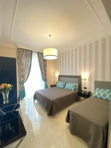 罗马康缇里亚酒店的一间卧室设有两张床和大窗户