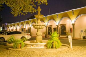 墨西卡利Hotel Cosmos Don Carlos的夜间在建筑物前的喷泉