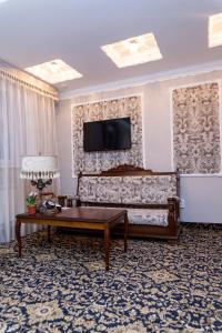 Ekibastuz将军酒店的客厅配有沙发和墙上的电视