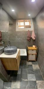 'Aïn TayaLes Falaises的浴室配有盥洗盆和浴缸。