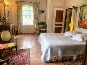 莫扎克和格朗德-卡斯唐Domaine de la Chartreuse Dautré的卧室配有床、椅子和窗户。