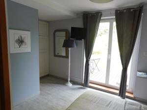 Saulcy-sur-MeurtheL'AMANDAURE的客房设有带窗帘和灯的大窗户。
