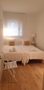 巴达洛纳Apartamento completo con piscina terraza vistas del mar的一间白色卧室,配有两张床和窗户