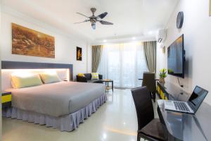 芭堤雅市中心Beautiful Apartment A6 Central Pattaya的一间卧室配有一张床和一张带笔记本电脑的书桌