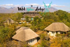 侯斯普瑞特The Wild Blue Lodge SAFARI & SPA的茅草小屋和野蓝色小屋标志的度假村