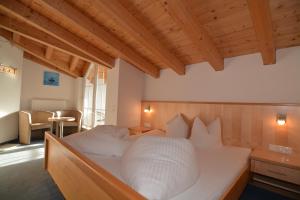 伊施格尔Garni Dorfblick的配有木制天花板的客房内一张白色大床