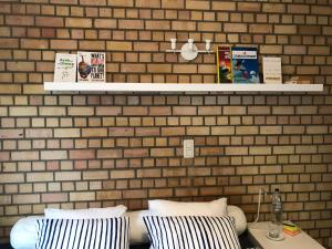 新鲁汶Lumineux appartement的一间设有砖墙、一张床和枕头的客房