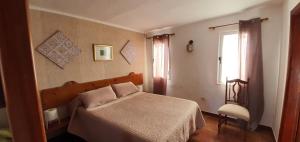 圣尼科拉斯村拉霍利亚旅舍 - 拉阿尔迪的一间卧室设有一张床、一个窗口和一把椅子