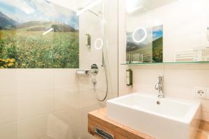 图克斯艾登酒店的白色的浴室设有水槽和淋浴。