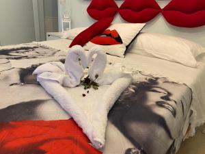 蒙赞巴诺Incanto del Garda的一张带毛巾的床和一个带心的床头板