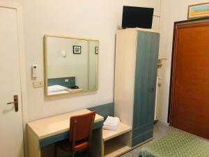 都灵Hotel Ferrucci的小房间设有书桌和镜子