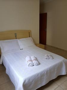 布罗塔斯Casa da Cachoeira的一张白色的床,上面有3条滚毛巾