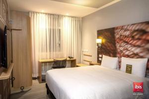 基多ibis Quito的酒店客房,配有床和电视