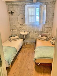 塔林Süda Hostel的配有水槽和窗户的客房内的两张床