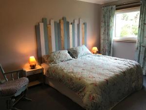凯里肯Strathspey的一间卧室配有一张带大型木制床头板的床