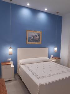 阿茨特雷扎Casa Vacanze RoSa的蓝色的卧室设有白色的床和蓝色的墙壁