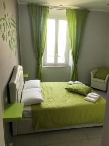 卡塞勒托瑞尼斯Rosa verde的一间卧室配有一张带绿色床单的床和一扇窗户。