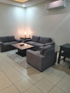 利雅德卡塔拉公寓式酒店的客厅配有沙发和桌子