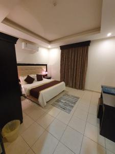 利雅德卡塔拉公寓式酒店的一间卧室设有一张大床和一个窗户。