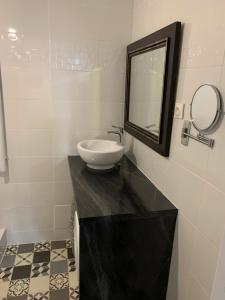 马赛T2 - Quartier mythique du panier的浴室设有水槽和镜子,位于柜台上