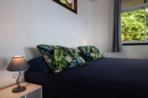 FitiiBienvenue au Mati House的一张带两个枕头的床和一张带台灯的桌子