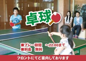 阿苏市格兰德里奥麻生度假酒店的一个小女孩在乒乓球桌玩乒乓球