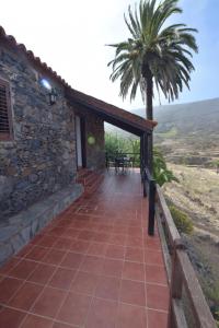 El CercadoCasas Rurales Los Manantiales的石头房子,带庭院和棕榈树