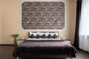 符拉迪沃斯托克斯比尔斯克坡德维烈酒店的一间卧室配有一张带毯子和挂毯的床