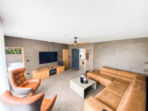 波切尼斯Penzión & Wellness MERIDIANA Bojnice rezort的客厅配有沙发、椅子和电视