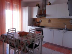 塔维亚诺Appartamento Pompea的厨房配有桌椅和水槽。