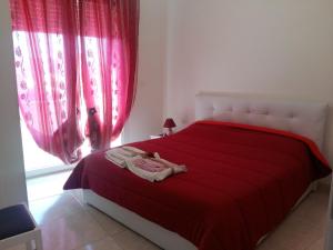 塔维亚诺Appartamento Pompea的一间卧室配有红色的床单和窗户