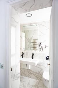 巴黎波拿巴特酒店的白色的浴室设有水槽和镜子